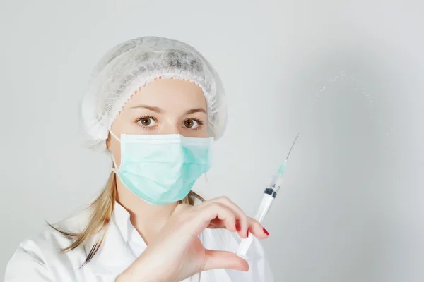 Una enfermera con un pinchazo y una máscara. — Foto de Stock