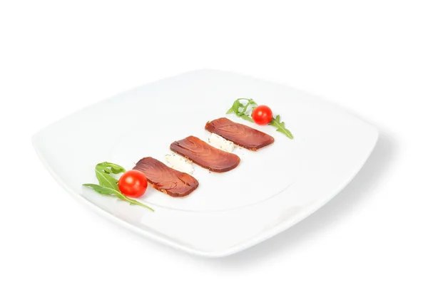 La composizione del tonno affumicato su un piatto. su uno sfondo bianco — Foto Stock