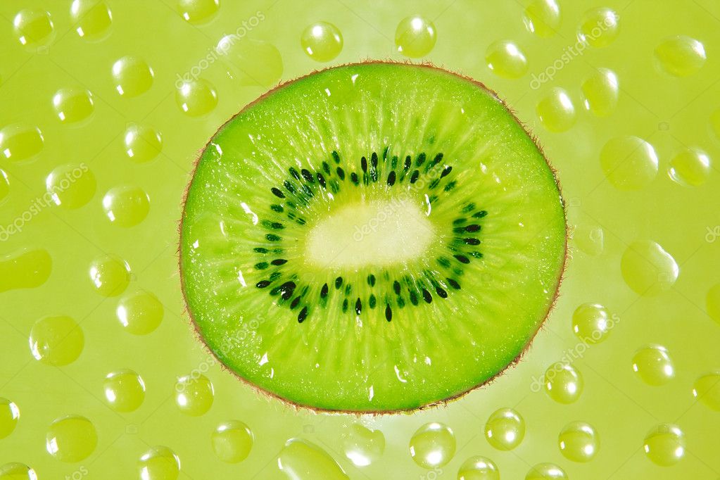 a fresh slice of kiwi fruit in green background drops. |圖庫照片