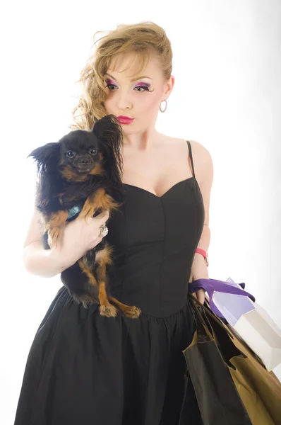 Joven rubia glamorosa con bolsa de compras sosteniendo juguete terrier perros sosteniendo perro —  Fotos de Stock