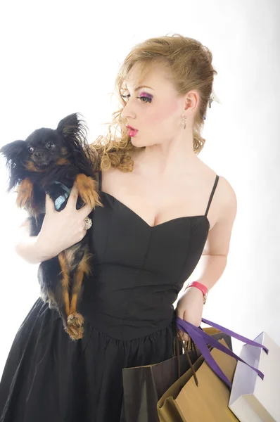 Young glamorous blonde with shopping bag holding toy terrier dogs holding dog — Stock Photo, Image