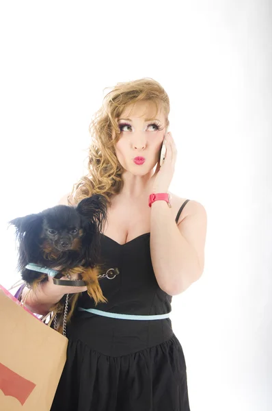 Shopping kvinna prata i telefon och hålla väskor håller hund — Stockfoto