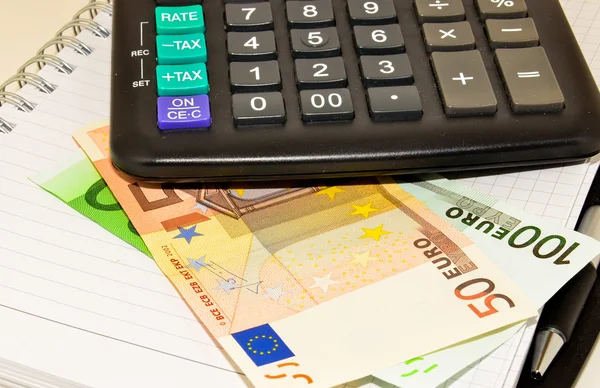 Calculadora, moedas e notas de euro — Fotografia de Stock