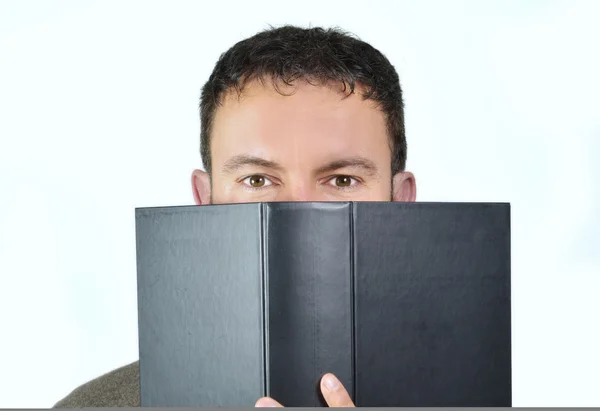 Good looking guy behind book – stockfoto