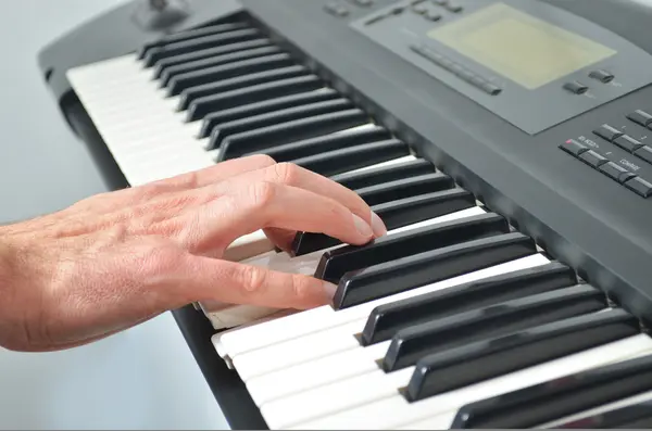 Hand playing electronic keyboard — Stock Photo, Image