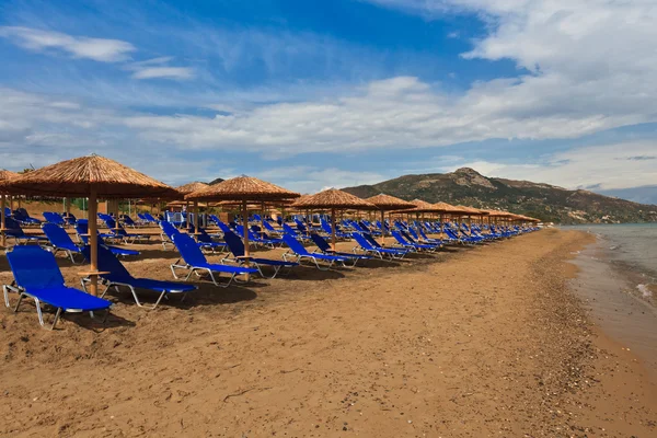 Een strand gevuld met ligstoelen — Stockfoto