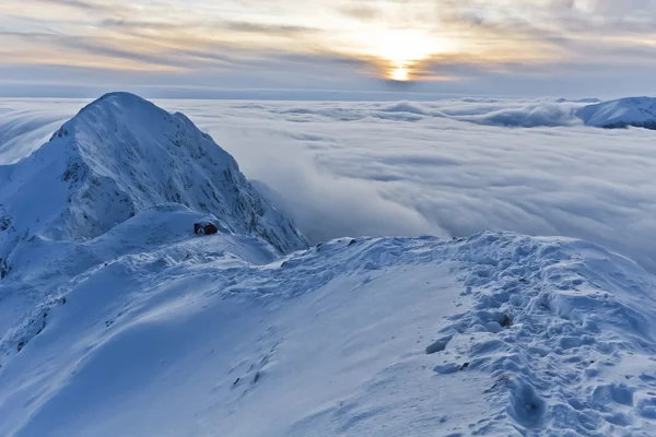 Закат над горами и облаками зимой — стоковое фото