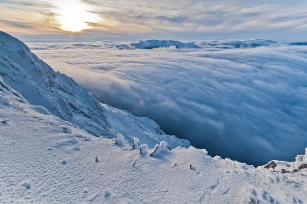 Sunset over the mountains and clouds in winter — Stock Photo, Image