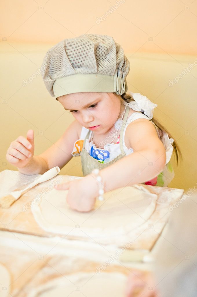 Little girl continue cooking pizza