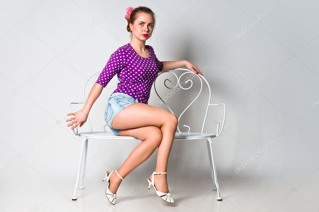 Pin up girl sitting on bench and looking