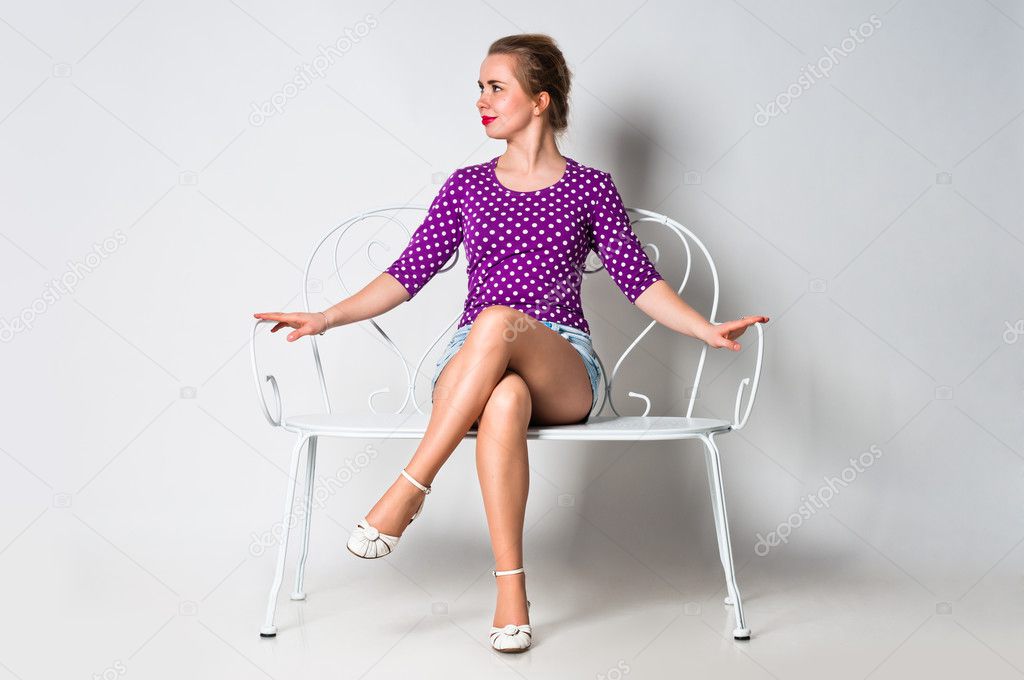 Pin up girl sitting on bench and smiling