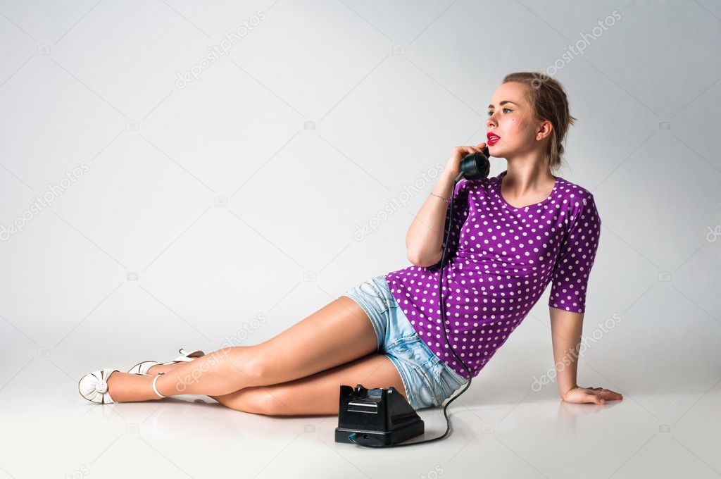 Pin up girl talking by vintage phone