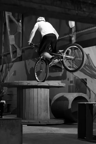 Велосипедист стоит на большой катушке на переднем колесе — стоковое фото