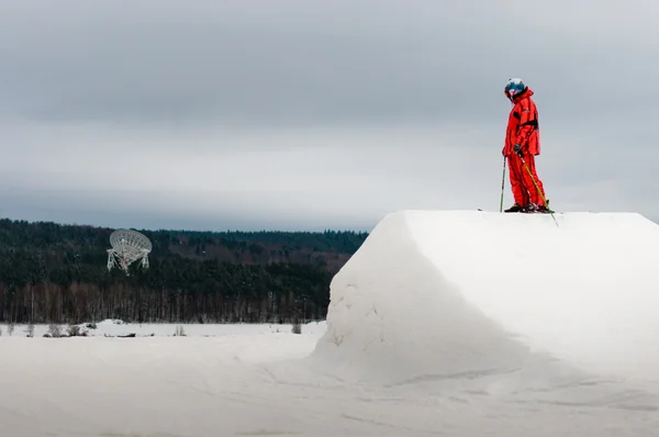 Sıçrama tahtası tepe üzerinde duran kayakçı — Stok fotoğraf
