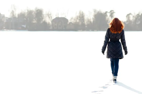 Mooi meisje lopen op bevroren meer — Stockfoto