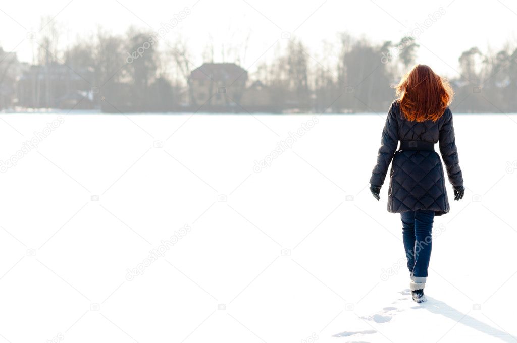 Pretty girl walking on frozen lake