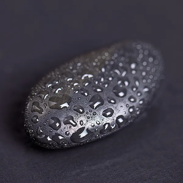 Zwarte steen met water drops — Stockfoto