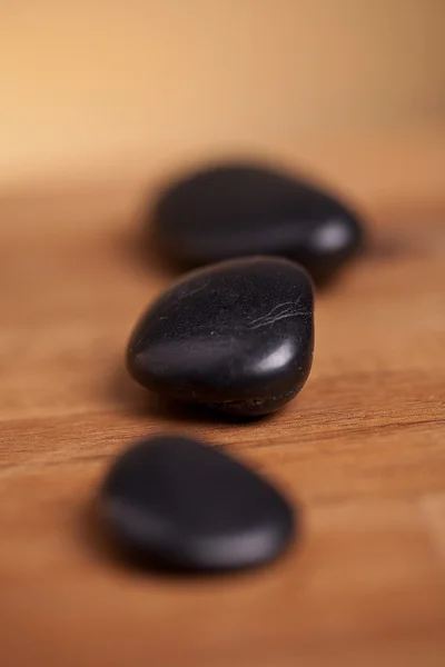 Piedras negras sobre fondo de madera —  Fotos de Stock