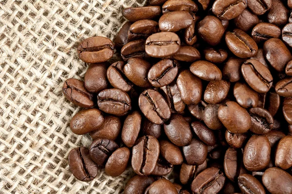 Hnědá kávová zrna na jutového pytle — Stock fotografie