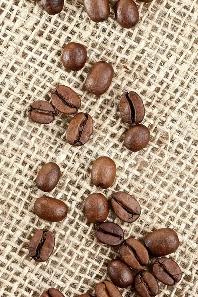 Braune Kaffeebohnen auf einem Jutebeutel — Stockfoto