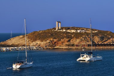 Yacht on front of the gate and the Naxos temple, Greece clipart