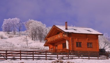 Wooden chalet in wintry view clipart