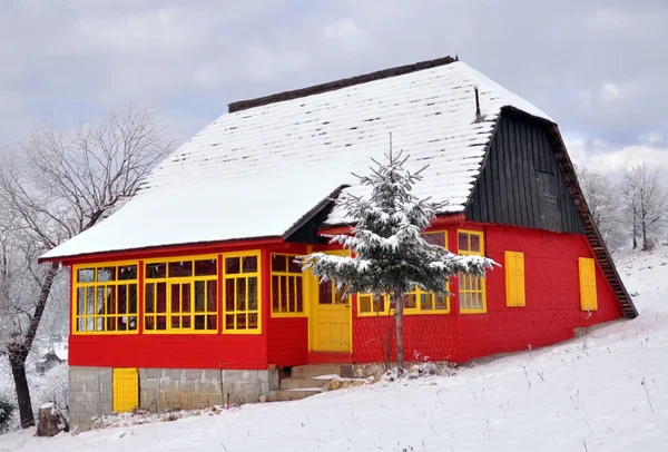 Rústico casa colorida com neve no telhado — Fotografia de Stock