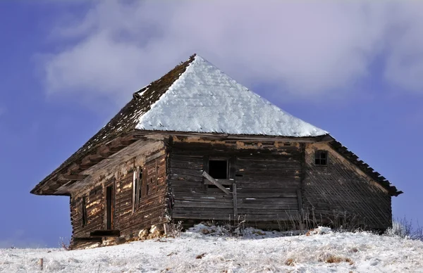 Opuštěné dřevěné chatě v zimním zobrazení — Stock fotografie