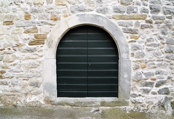 Wooden door on stone wall — Stock Photo, Image