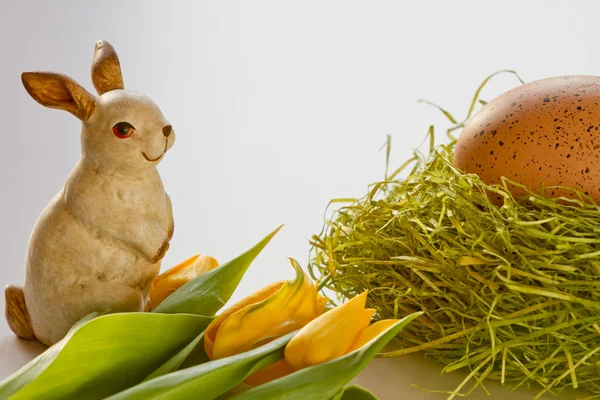 Ovo de éter pintado com coelho da Páscoa e flores amarelas — Fotografia de Stock