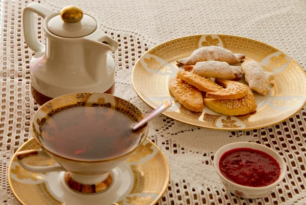 Чашка чая и свежие домашние кучи печенья — стоковое фото