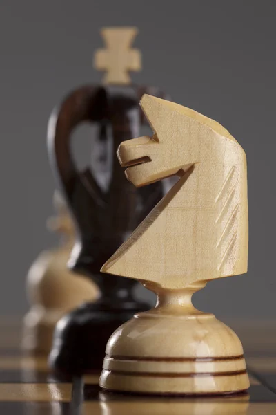 Белый рыцарь и черный король на шахматной доске — стоковое фото