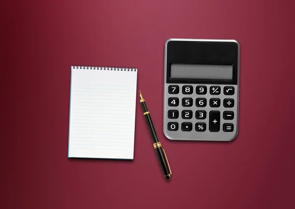 Calculadora, un bolígrafo y papel en blanco sobre la mesa — Foto de Stock