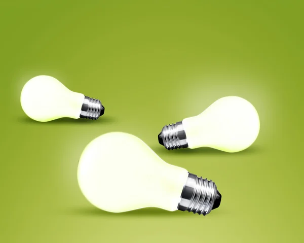 Tři zářící světlo žárovka idea na zeleném pozadí — Stock fotografie