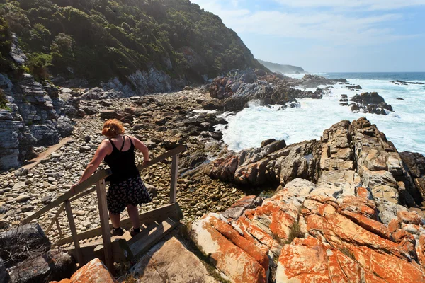 Femme randonnée le long de la côte rocheuse — Photo