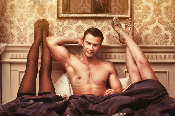 Mladý muž se dvěma ženami v ložnici — Stock fotografie