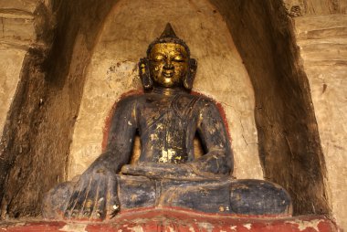 Statue of buddha with golden head in Thatbyunnyu Pahto temple in Bagan - M clipart