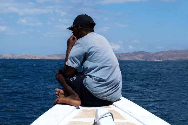 Indonezyjski łodzi człowiek siedzi przed jego statek na morzu — Zdjęcie stockowe