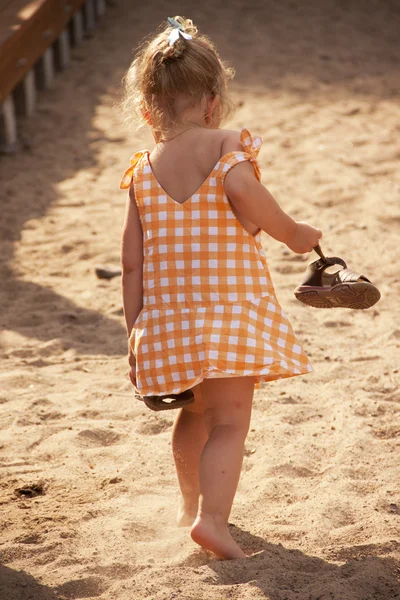 Barefoot little girl walking on beach — Stock Photo, Image