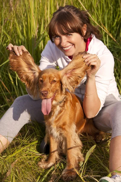 웃는 여자는 그녀의 강아지와 재미는 스톡 사진