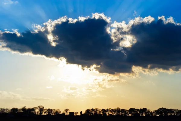 Nap sugarai fény, sötét, baljós felhők segítségével — Stock Fotó