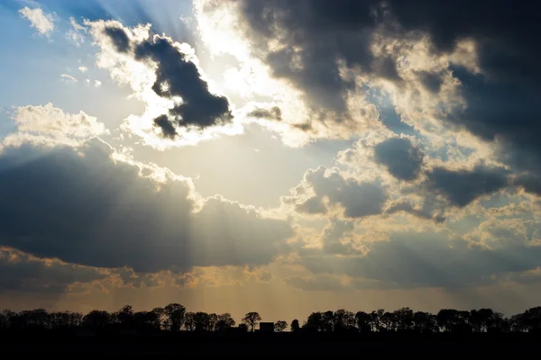 Solen strålar beam genom mörka olycksbådande moln — Stockfoto