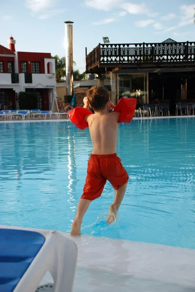 Boy jumping into the swimming pool Stock Image