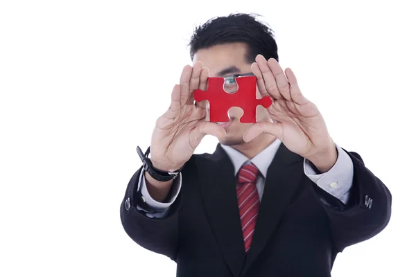 Businessman showing a piece of puzzle — Stock Photo, Image