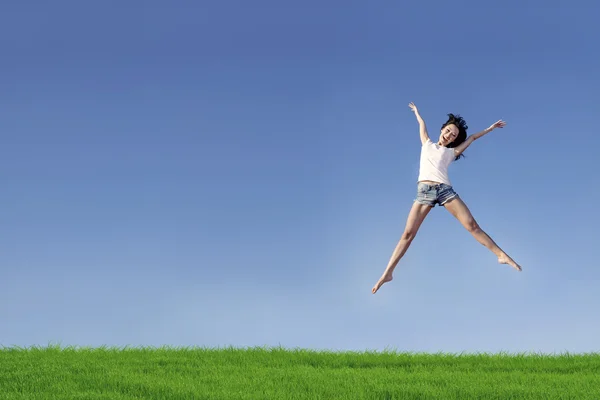 Mulher excitada pulando sobre o céu azul — Fotografia de Stock