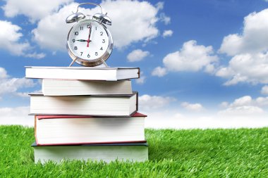 Alarm clock and stack of books clipart