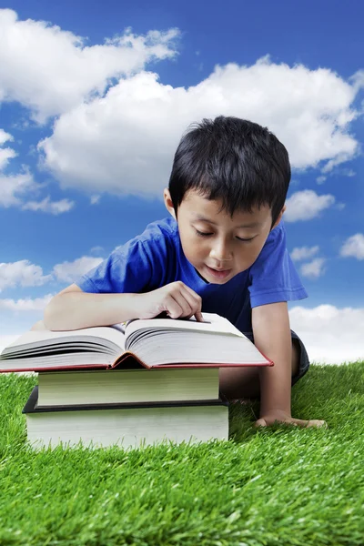 在草地上读书的男孩 — 图库照片