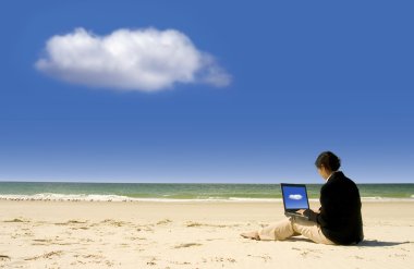 Businesswoman working with laptop at beach clipart