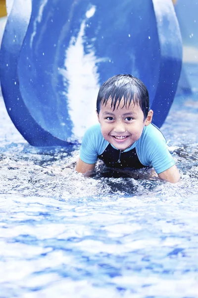 Feliz asiático niño en tobogán de agua — Foto de Stock