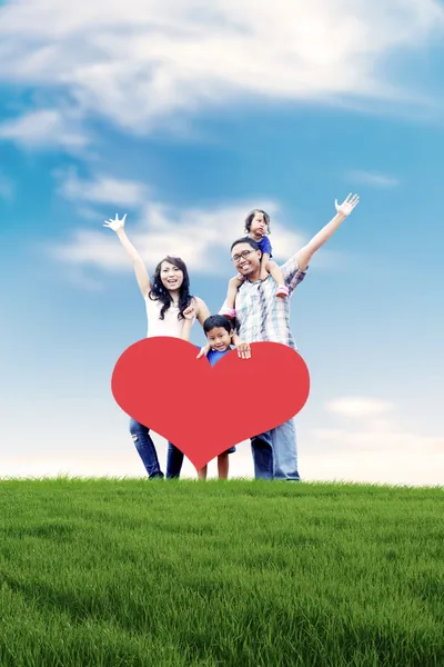 Happy Asian family in Meadow Stock Photo